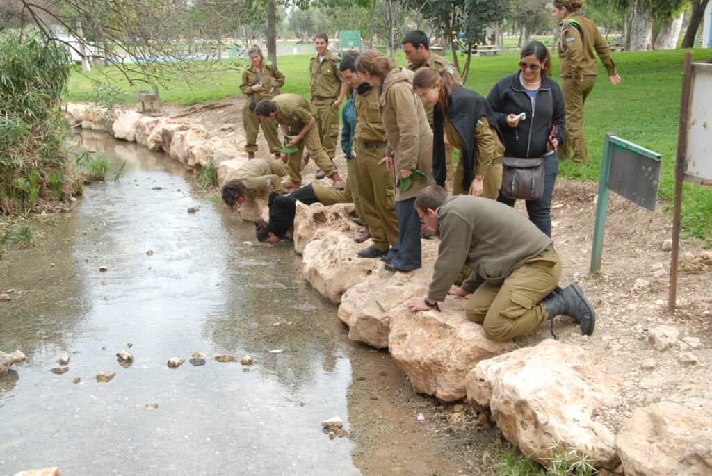 Israeli soldiers reenacting Gideon's soldiers drinking from the Harod Spring.